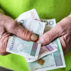 Dłonie trzymają polskie banknoty: 10, 20 i 100 zł. Zastanawiasz się, ile wynosi renta na depresję?