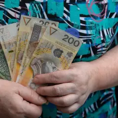 Dłonie trzymają polskie banknoty. Czy renta zależy od zarobków? To pytanie nurtuje wiele osób, gdy widzą takie kwoty.
